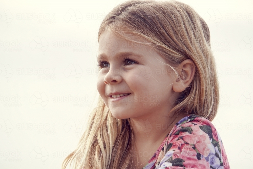Profile view of five year old girl smiling - Australian Stock Image