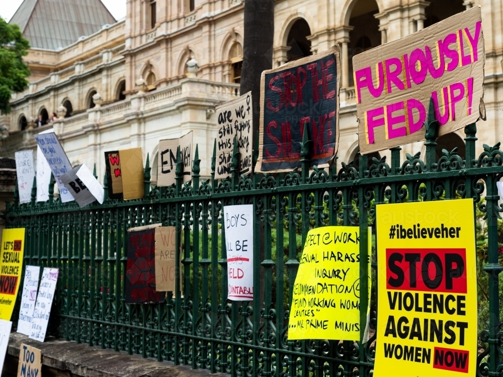 Protest signs on a fence outside a grand old building - Australian Stock Image