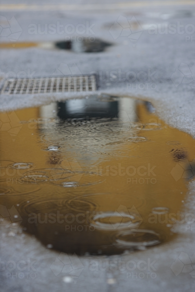 puddle on city street - Australian Stock Image