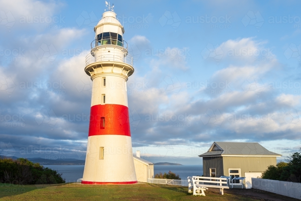 Puffy clouds above a brightly painted lighthouse - Australian Stock Image