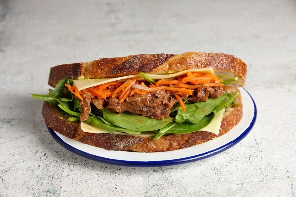 Pulled beef, cheese and salad sandwich on sourdough bread - Australian Stock Image
