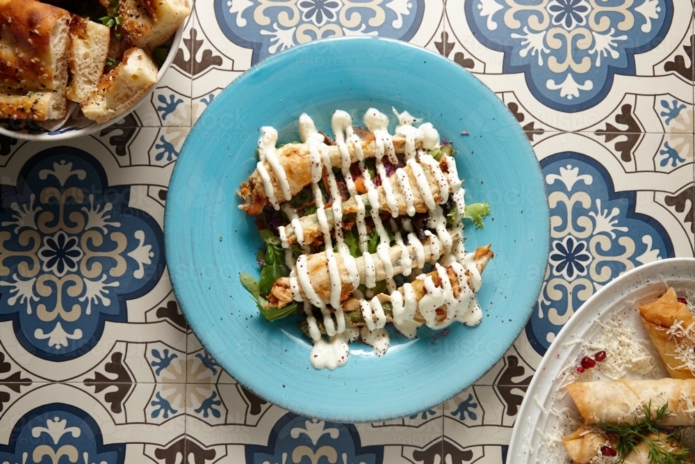pumpkin flowers covered in mayonnaise on a blue plate - Australian Stock Image