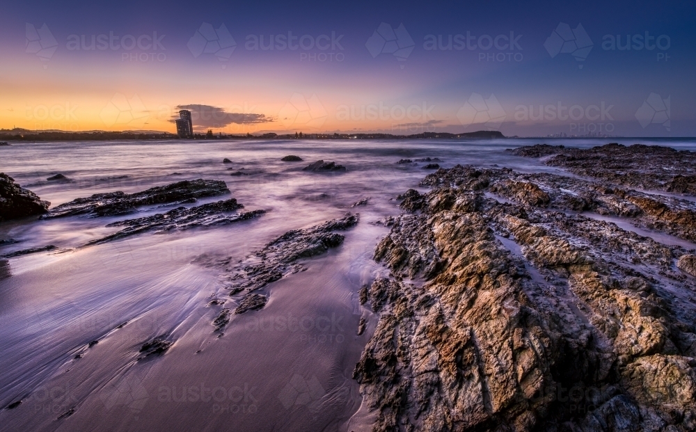 Purple and blue seascape sunset over rocks - Australian Stock Image