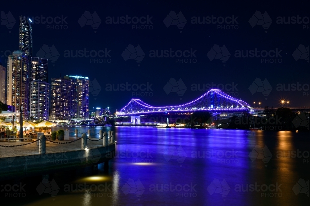 Purple reflections on the Brisbane River with the Storey Bridge and a dark blue night sky - Australian Stock Image