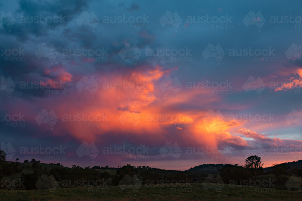Purple storm clouds over the Australian landscape at sunset - Australian Stock Image