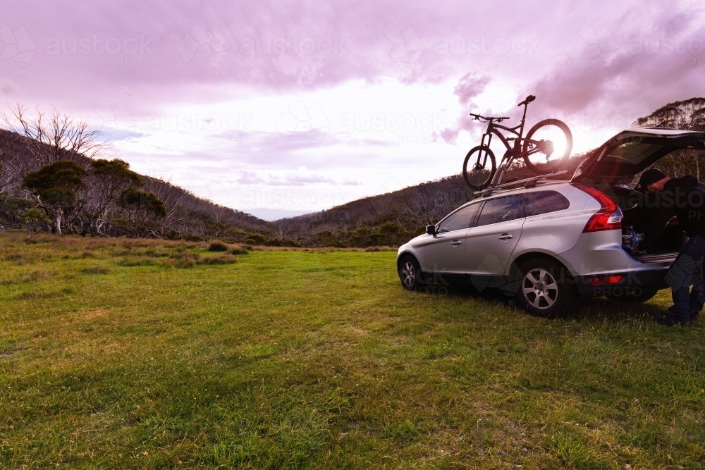 Purple sunset at Dead Horse Gap with SUV and mountain bike on top - Australian Stock Image