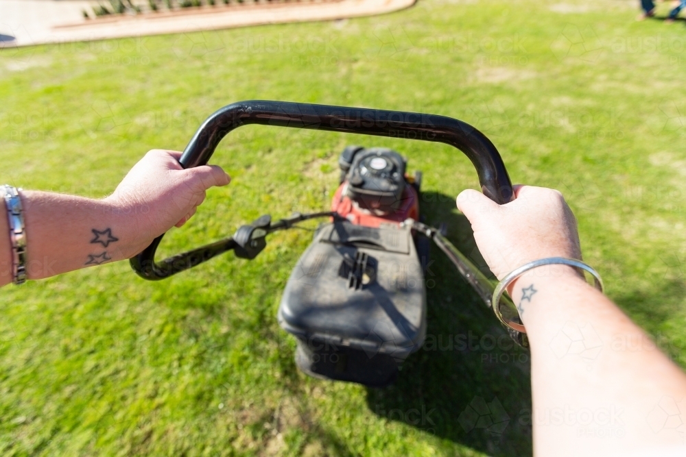 pushing a lawnmower - Australian Stock Image