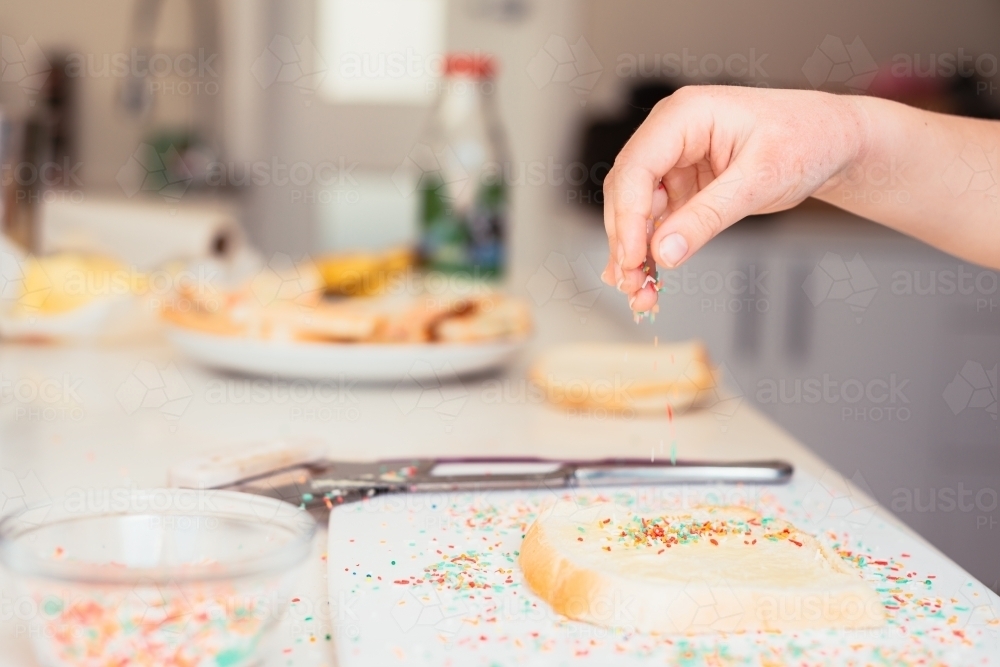 Image of Putting sprinkles on fairy bread Austockphoto