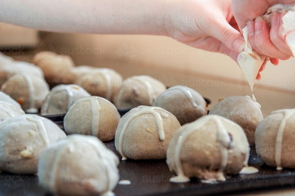 Image of Putting the crosses on hot cross buns Austockphoto