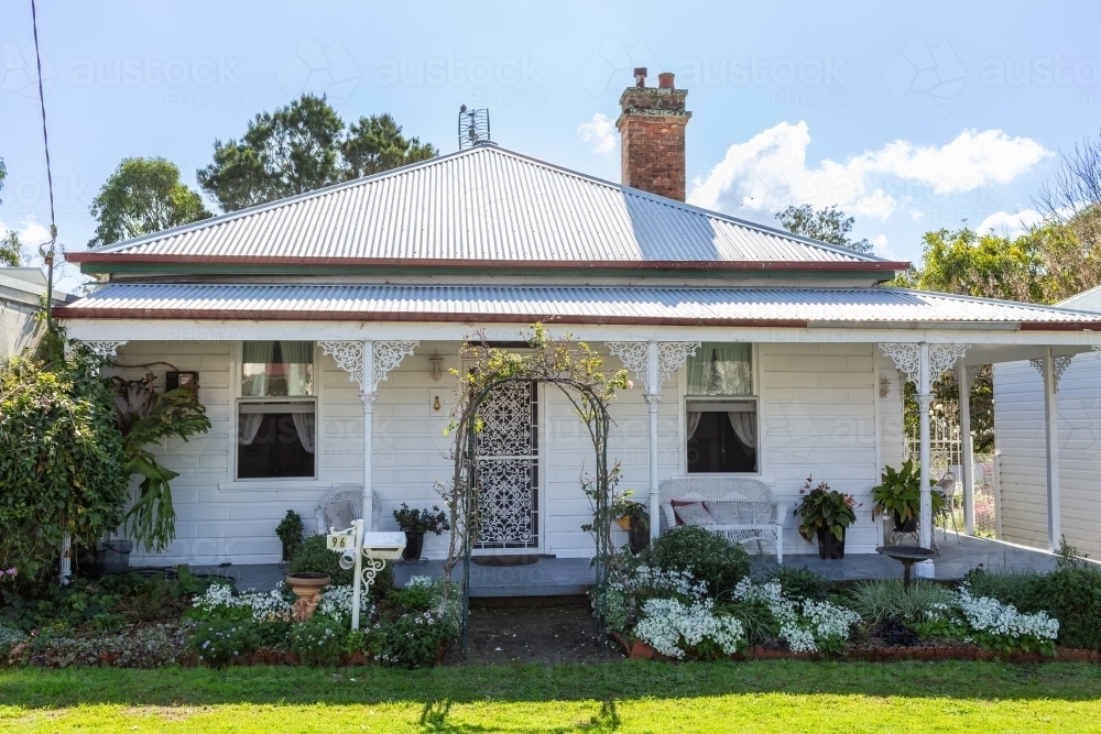 Quaint white old style house with neat garden and veranda in country town - Australian Stock Image