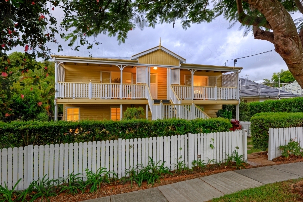 Queenslander home in Brisbane photographed at dusk - Australian Stock Image