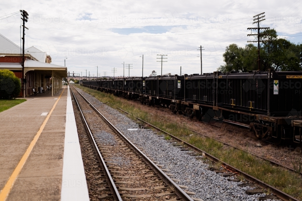 Railway track, platform and railway trucks at Harden railway station - Australian Stock Image