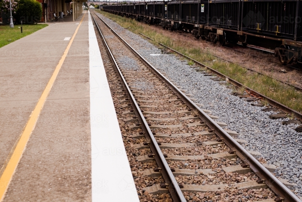 Railway track, platform and railway trucks at Harden railway station - Australian Stock Image