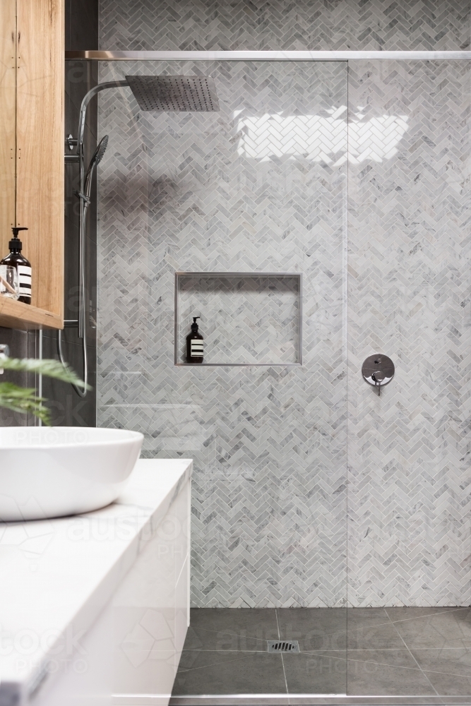 Image of Rain shower with herringbone marble feature tile wall - Austockphoto