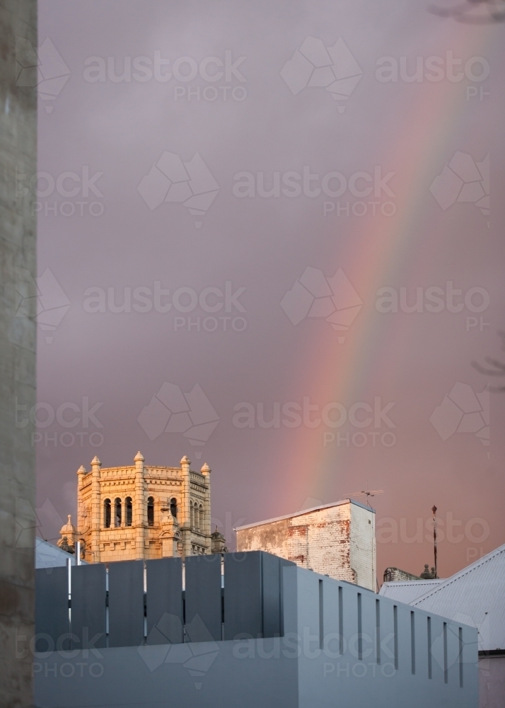 Rainbow above buildings in a city - Australian Stock Image