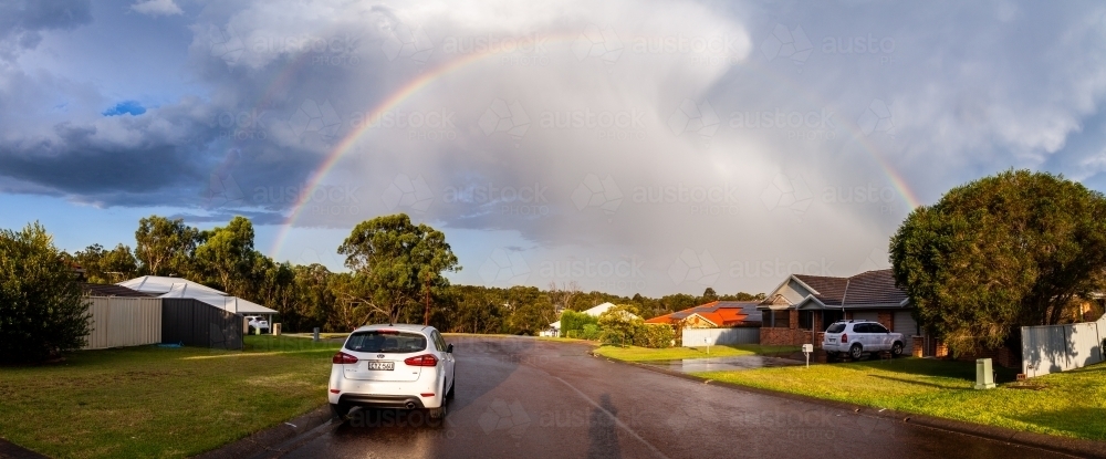 Rainbow and clouds after wet rainstorm over suburbs - Australian Stock Image