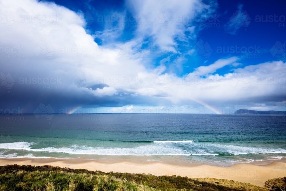 Rainbow and Rain Clouds over ocean - Australian Stock Image