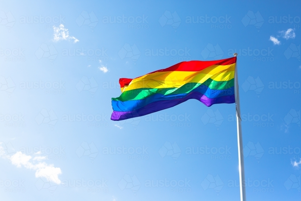 Rainbow flag against a blue sky - Australian Stock Image