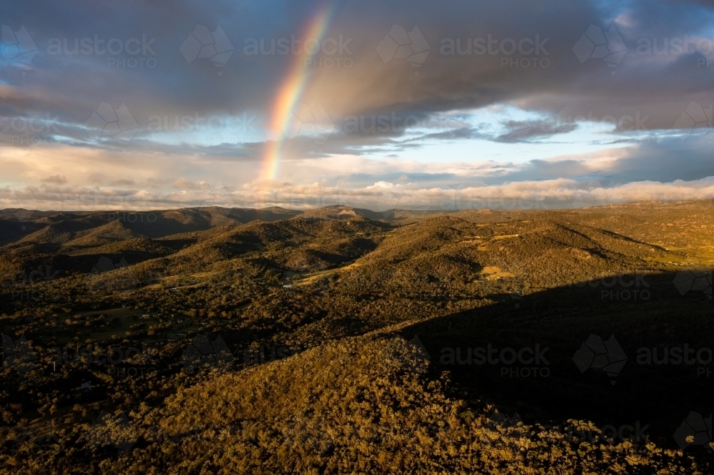 Rainbow over granite belt landscape - Australian Stock Image
