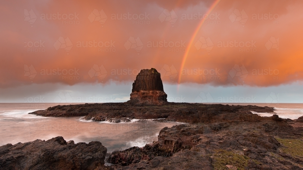 Rainbow over Pulpit Rock, Cape Schank at sunrise - Australian Stock Image