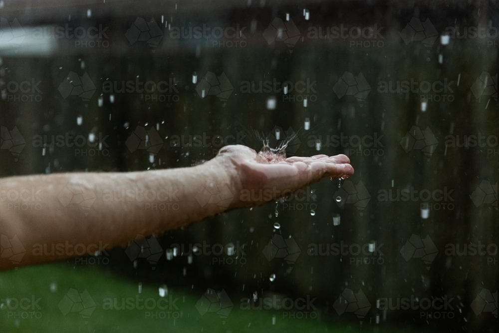 raindrop splashing on a hand - Australian Stock Image