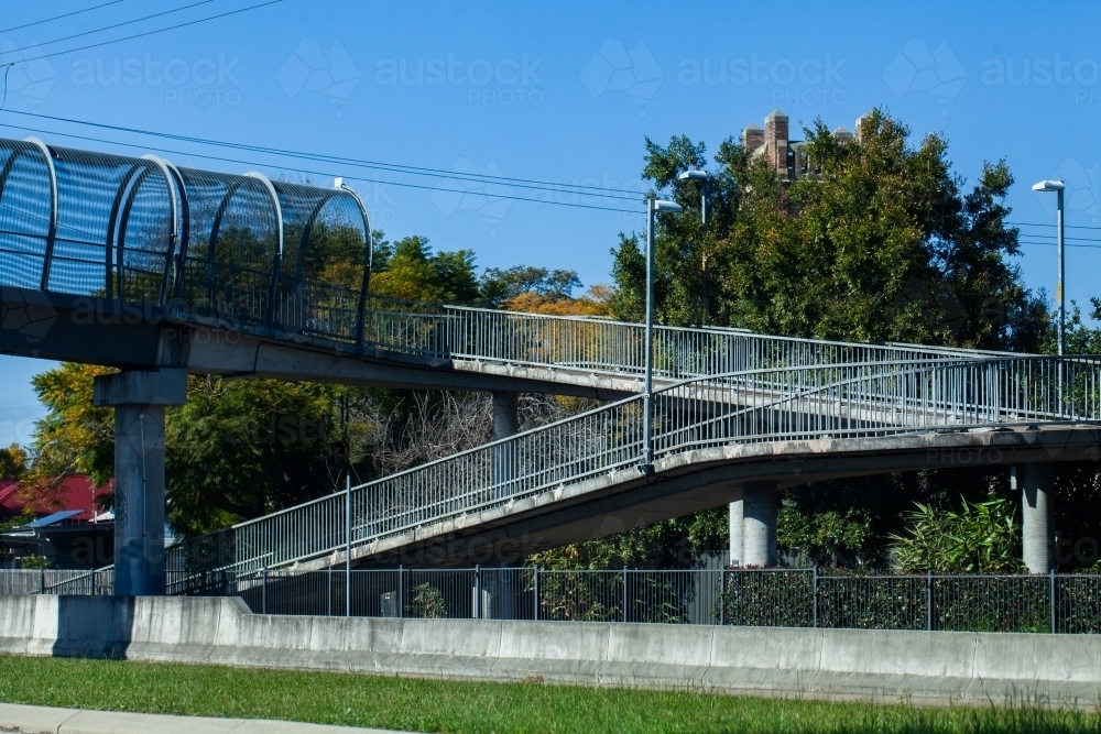 Image of Ramp up pedestrian bridge to cross over busy road - Austockphoto