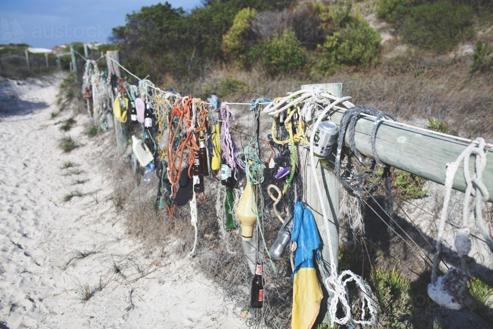 Random fishing and beach gear on fence at the beach - Australian Stock Image