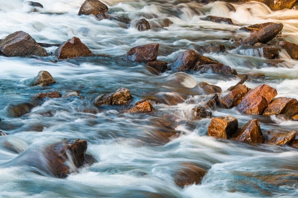 Rapid water moving along a rocky river bed : Austockphoto Rapid water moving along a rocky river bed - Australian Stock Image