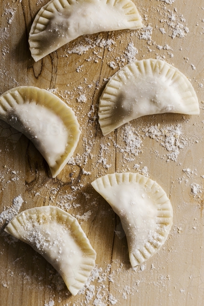 Raw dumplings on wood board - Australian Stock Image