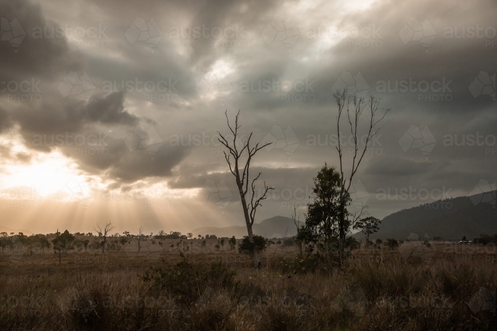 rays of sunlight breaking through the clouds over farmland - Australian Stock Image