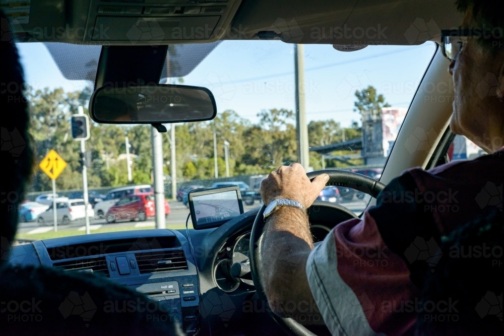 Rear view of driver looking through windscreen to busy road. - Australian Stock Image