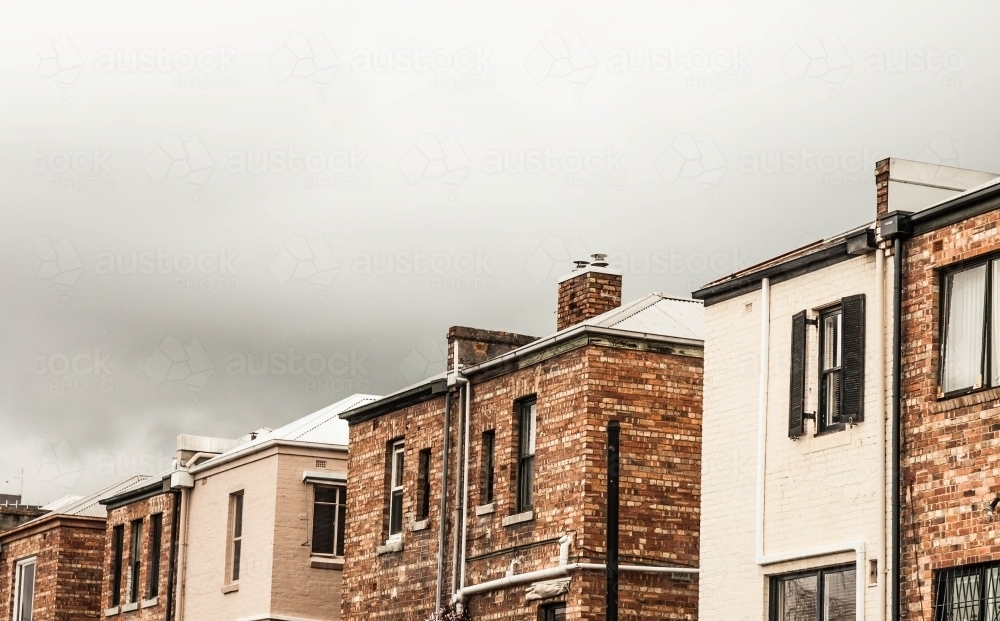 rear view of Melbourne terrace houses under an ominous sky - Australian Stock Image