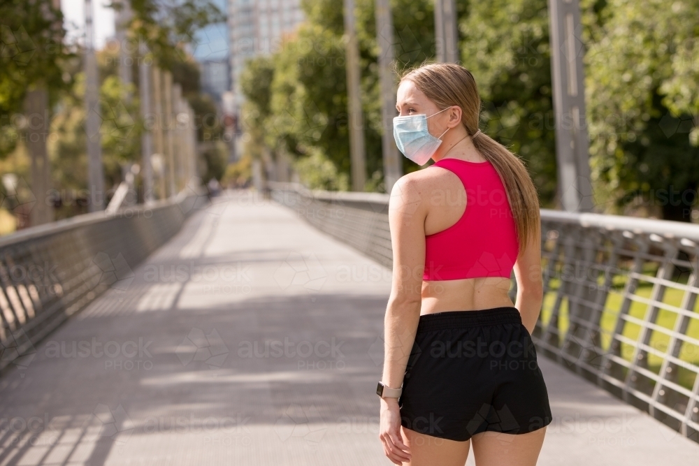 Rear View of Young Woman in Mask - Australian Stock Image