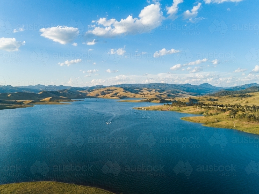 Recreation area beside dam, boat over water in Lake St Clair Hunter Valley - Australian Stock Image