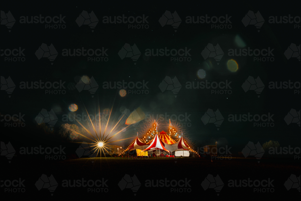 Red and white big top circus tent visiting small town in rural Australia illuminated at night under - Australian Stock Image