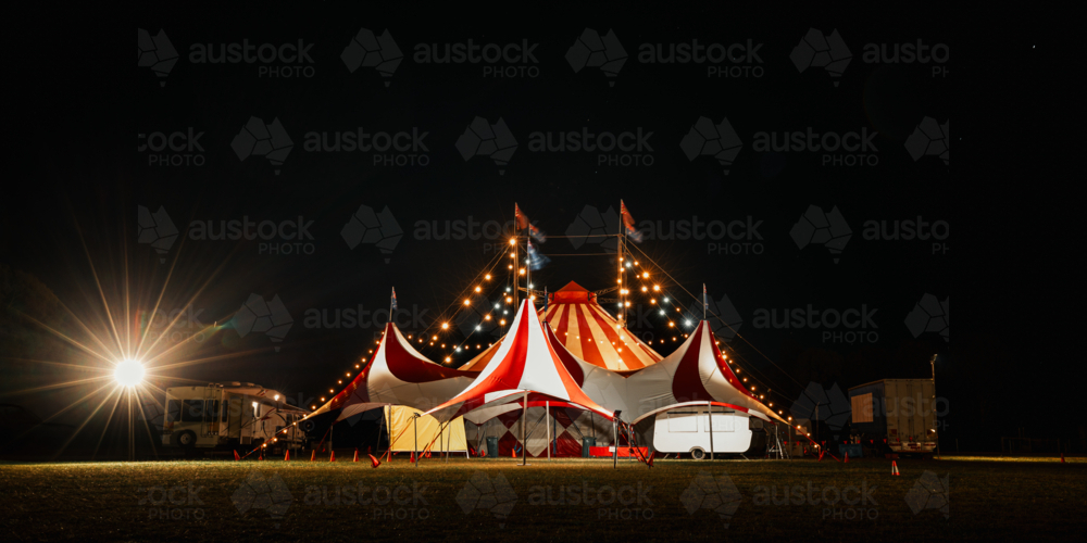 Red and white big top circus tent visiting small town in rural Australia illuminated at night - Australian Stock Image