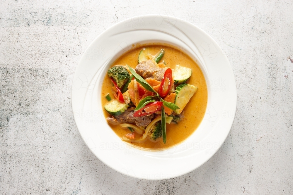 Red curry dish on table - Australian Stock Image
