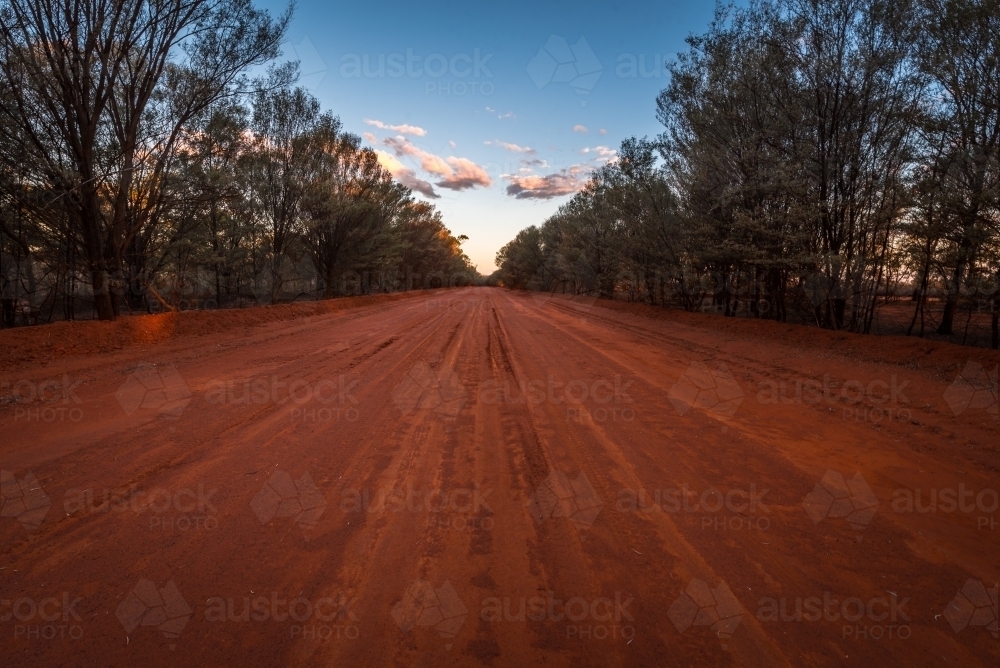 Red dirt road at dusk in Australian outback - Australian Stock Image