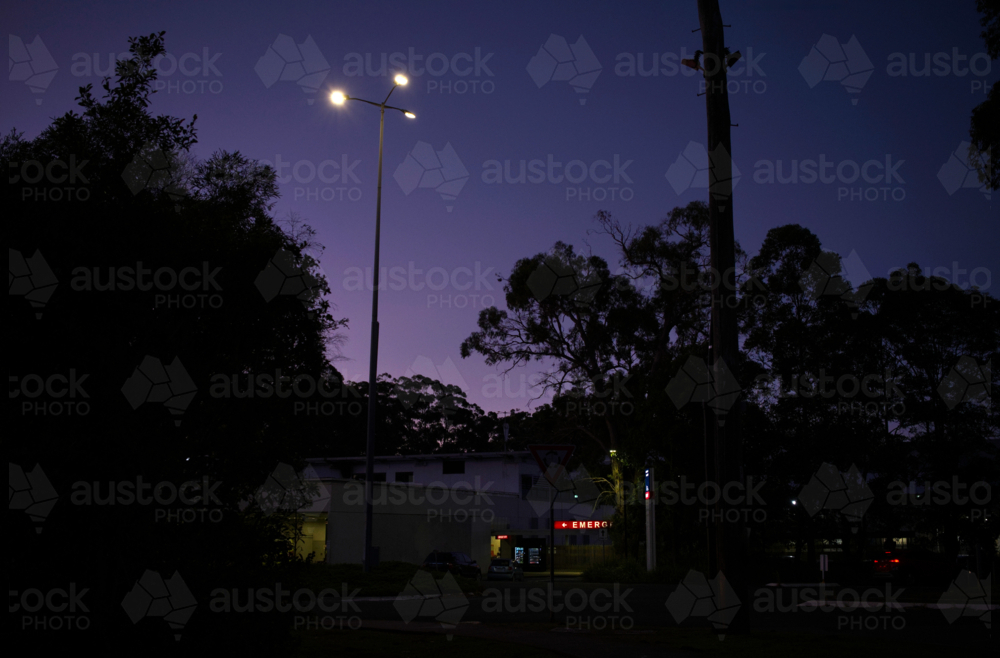 Red emergency sign illuminated at nightfall - Australian Stock Image