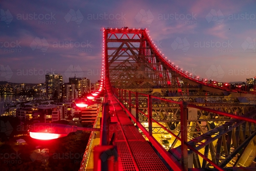 Red illuminated lights along the structure of the Story Bridge at dusk. - Australian Stock Image