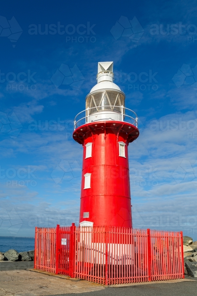 Red lighthouse with white top section at Fremantle Harbour Entrance. - Australian Stock Image