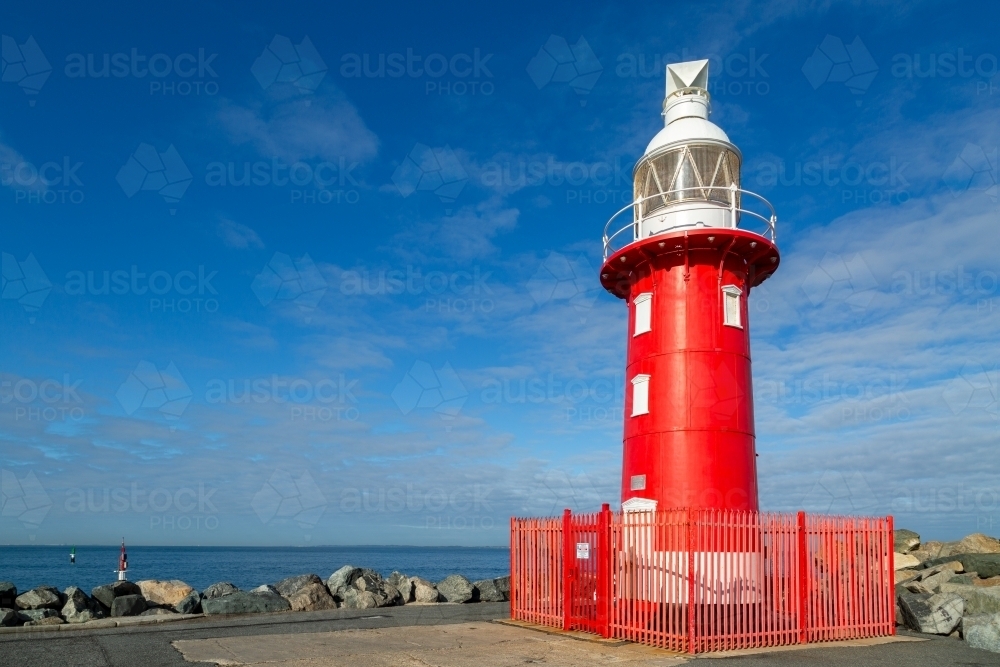 Red lighthouse with white top section at Fremantle Harbour Entrance. - Australian Stock Image