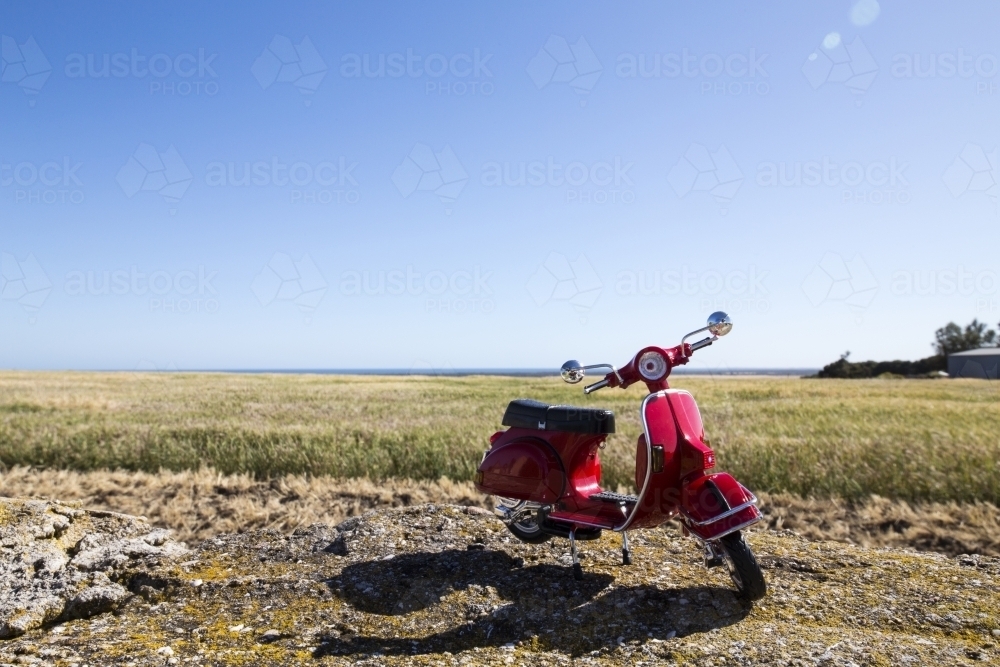Red motorbike on right with paddock behind - Australian Stock Image