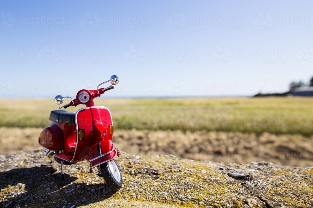 Red motorbike parked on left with paddock behind - Australian Stock Image