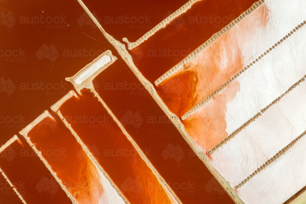 Red salt ponds divided by pale geometric walls - Australian Stock Image