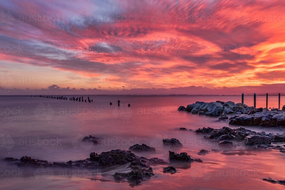Red sunrise at Bridport Old Pier, Tasmania - built in 1916; destroyed by fire in 1941 - Australian Stock Image