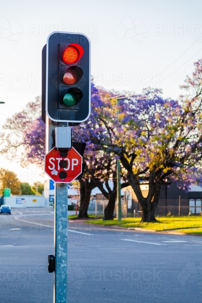 Image of Red traffic light and stop sign at intersection Austockphoto