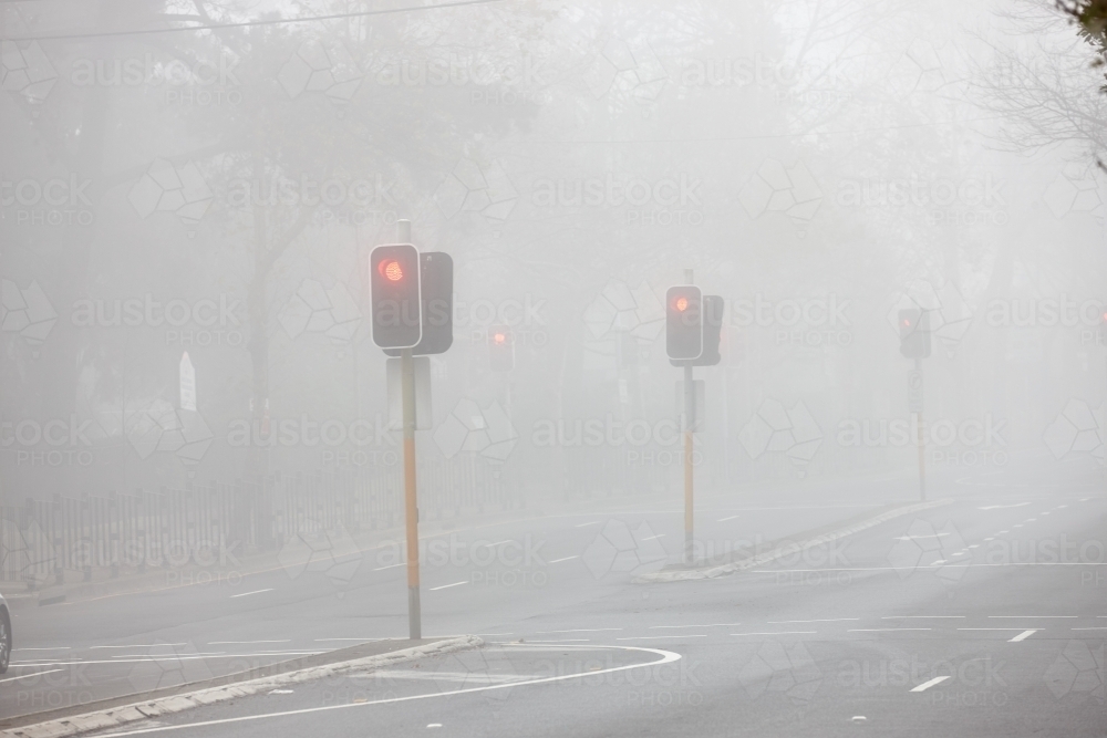 Red traffic lights in early morning fog - Australian Stock Image