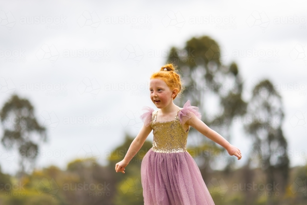 redhaired child outside with blurred background - Australian Stock Image