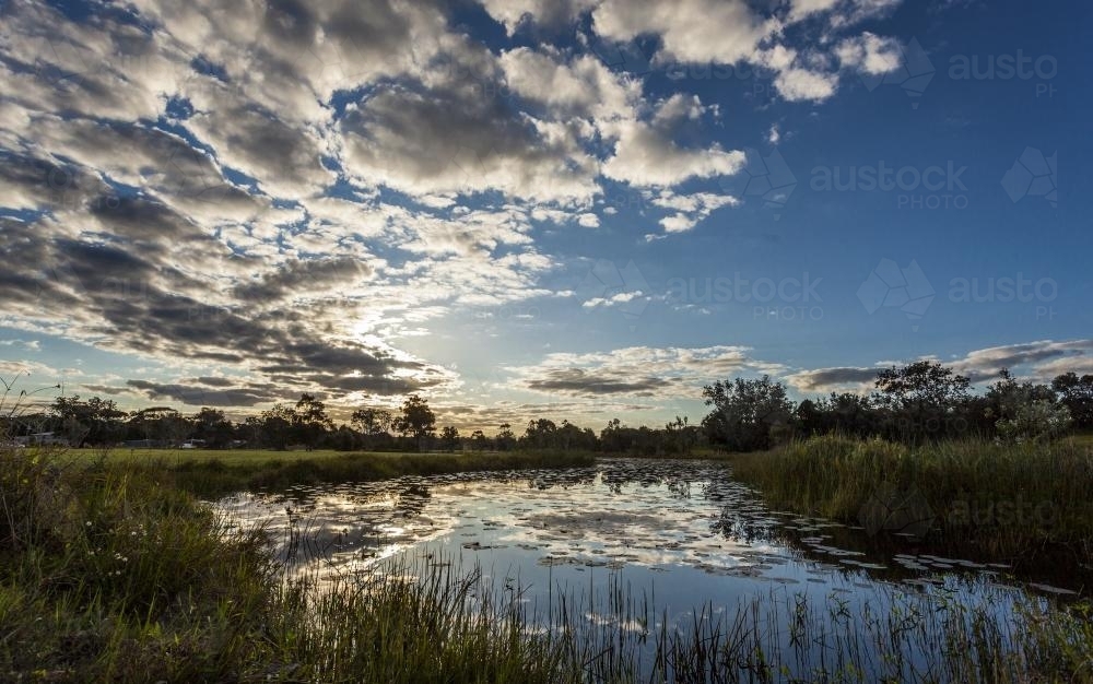 reflection in a lake with surrounding bushland and sky - Australian Stock Image